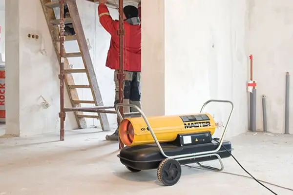 Contractors using a diesel space heater inside a new build to demonstrate QuoteMeHire site heating equipment hire