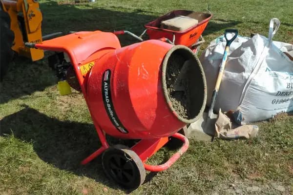 Cement mixer half full with concrete positioned on site ready for mixing mortar and aggregate.