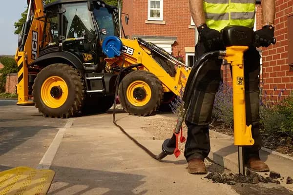 Hydraulic breaker and power pack used on a construction site by an operator for heavy-duty breaking work.